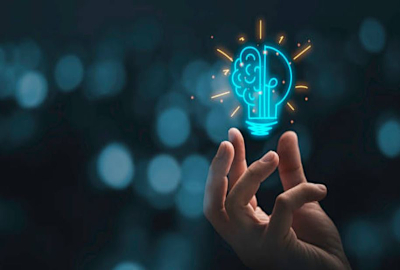 varigated dark blue background with a hand holding up a lightbulb half of which is showing a brain